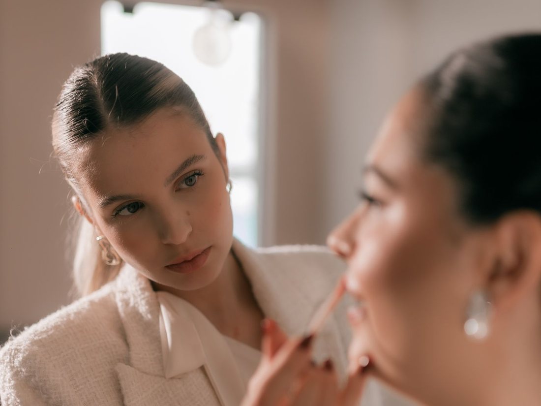 Aisha applying makeup to a client during a bridal trial